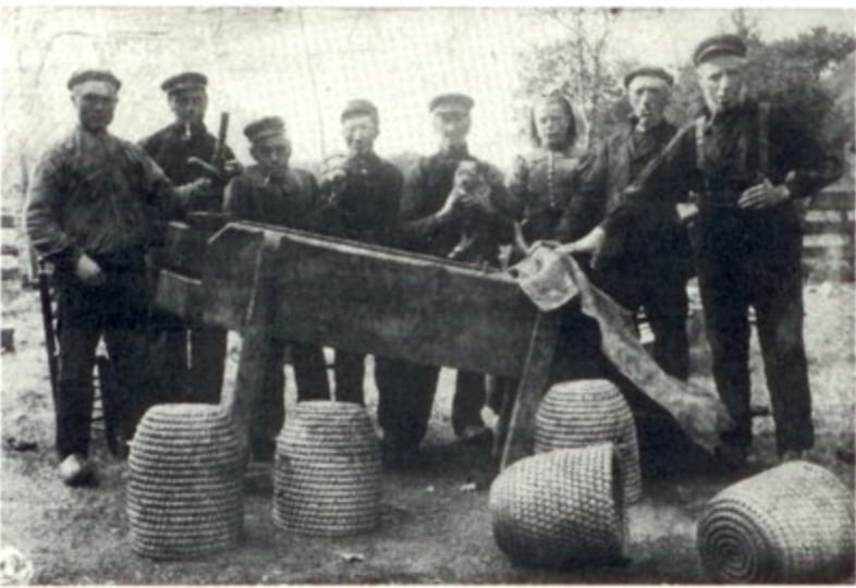 Een juweeltje honing persen in 1905. Van links naar rechts: Jan Smid, Albert Huizing, Jan Huizing, Jan Braam, Frederik Braam, Margje Smid, Albert Smid en Jan Hagting.