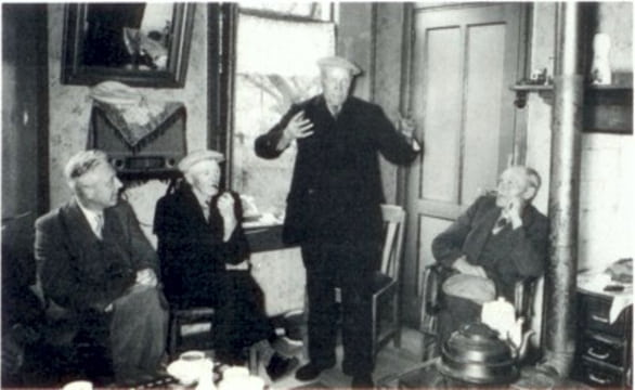 Jachtverhalen bij de kachel. De haas werd steeds groter. Van links naar rechts: T. Leever, J. Hartlief, Js. Meems en M. Veenhof ± 1950